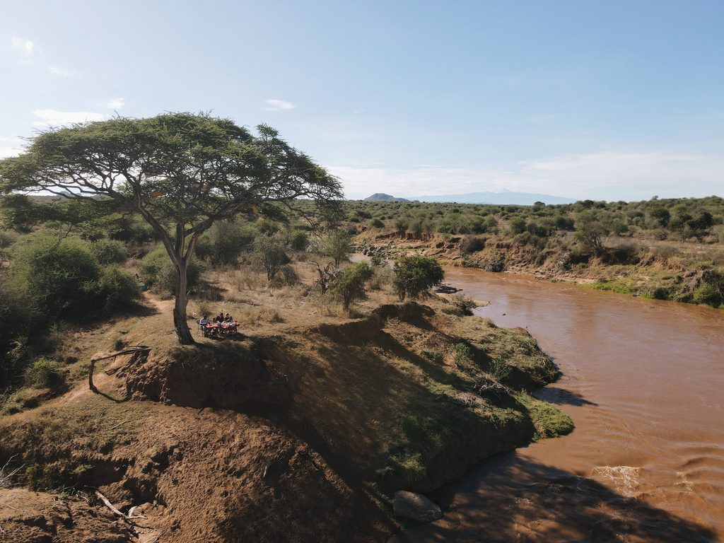 Landschap in Kenia, Laikipia met zicht op een rivier, de savanne, en bergen in de verte.
